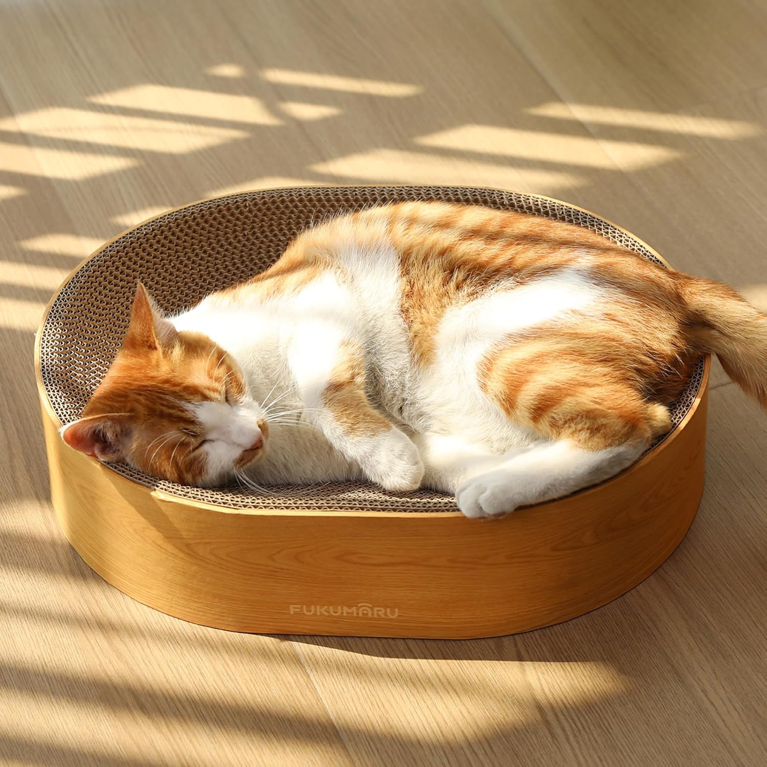 FUKUMARU cardboard cat scratcher lounge bed front view showing the oval bowl design and modern wood color trim.