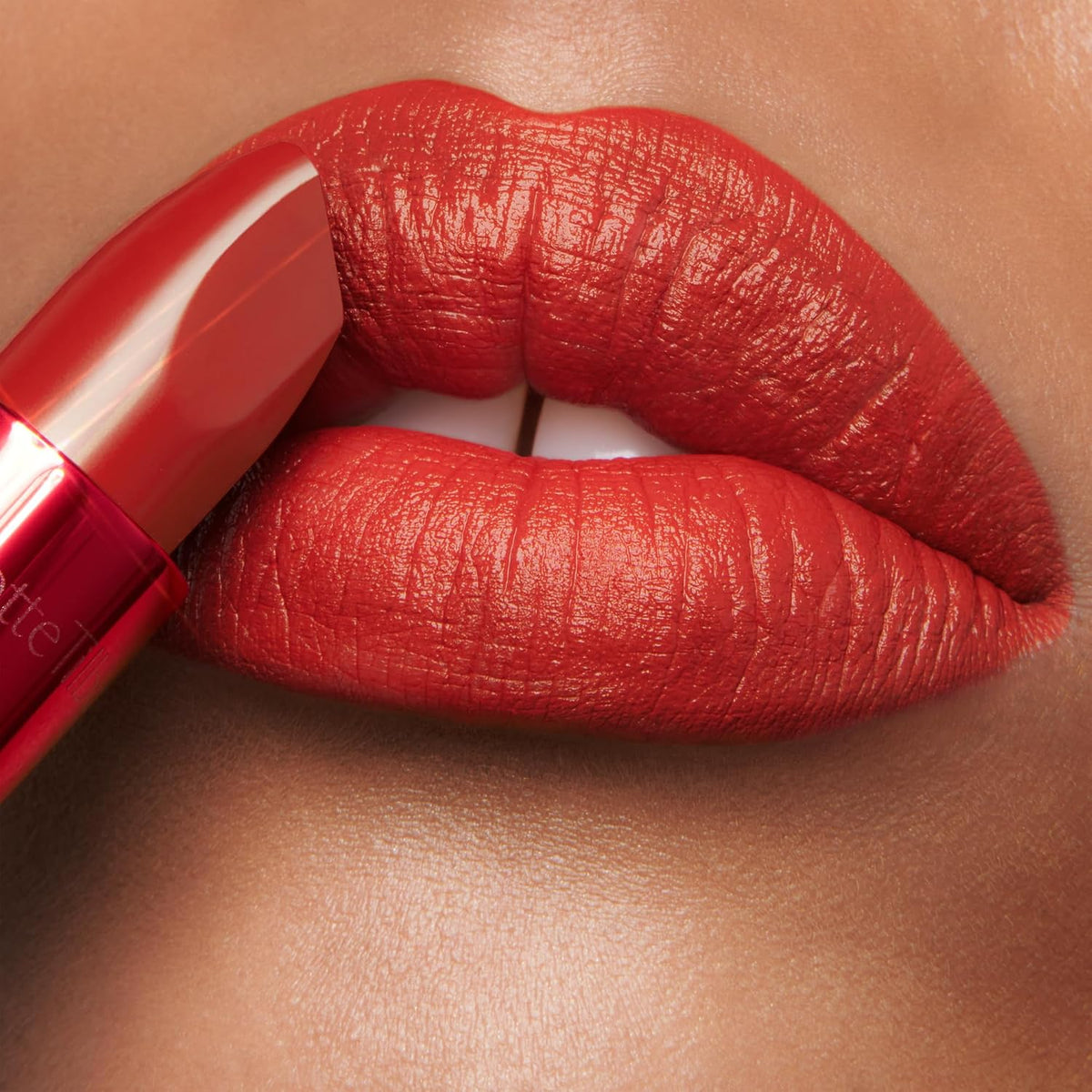 Premium USA imported Charlotte Tilbury Matte Revolution red lipstick unboxed showing the modern velvety texture.