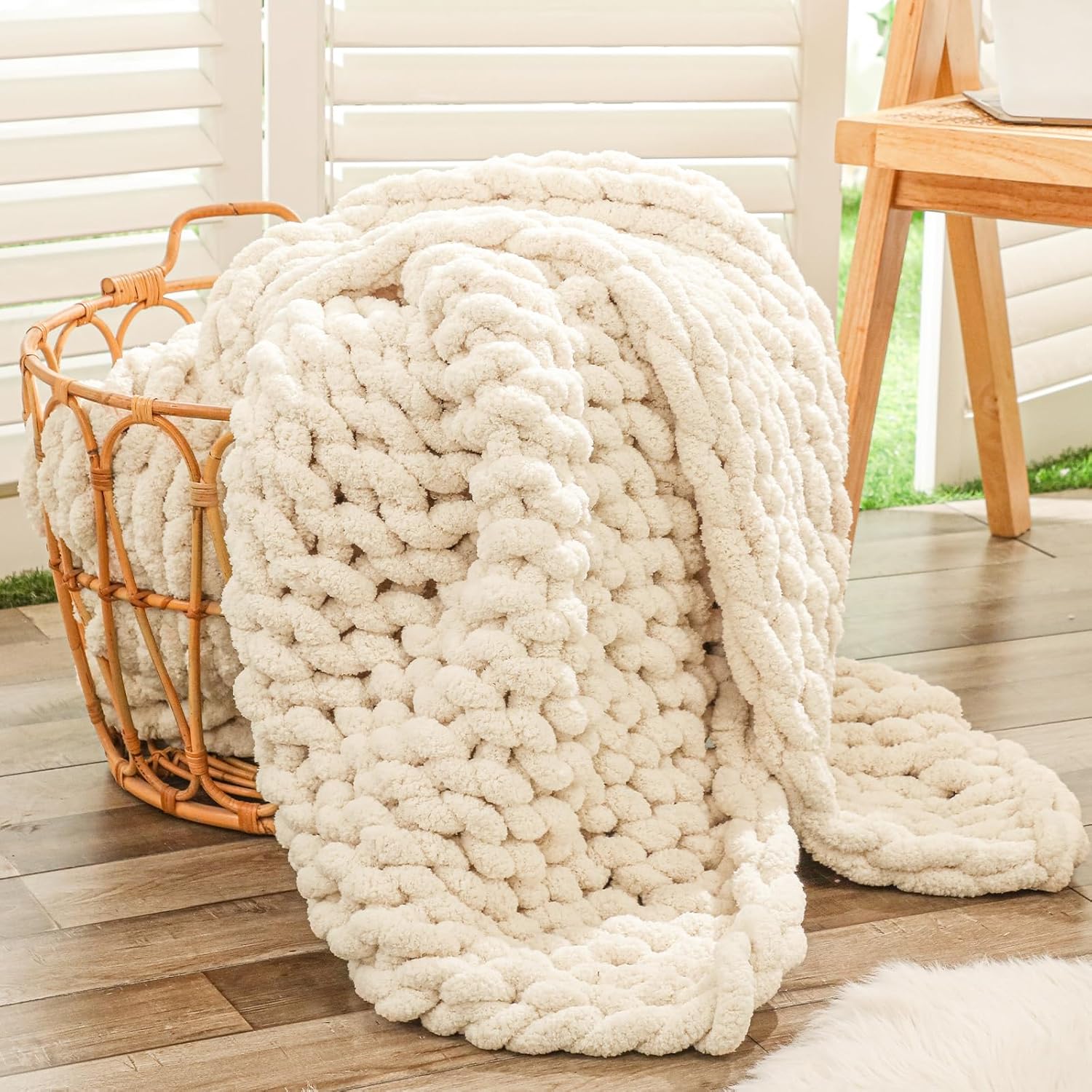 Bigacogo chunky knit throw blanket in beige displayed on a modern living room couch.