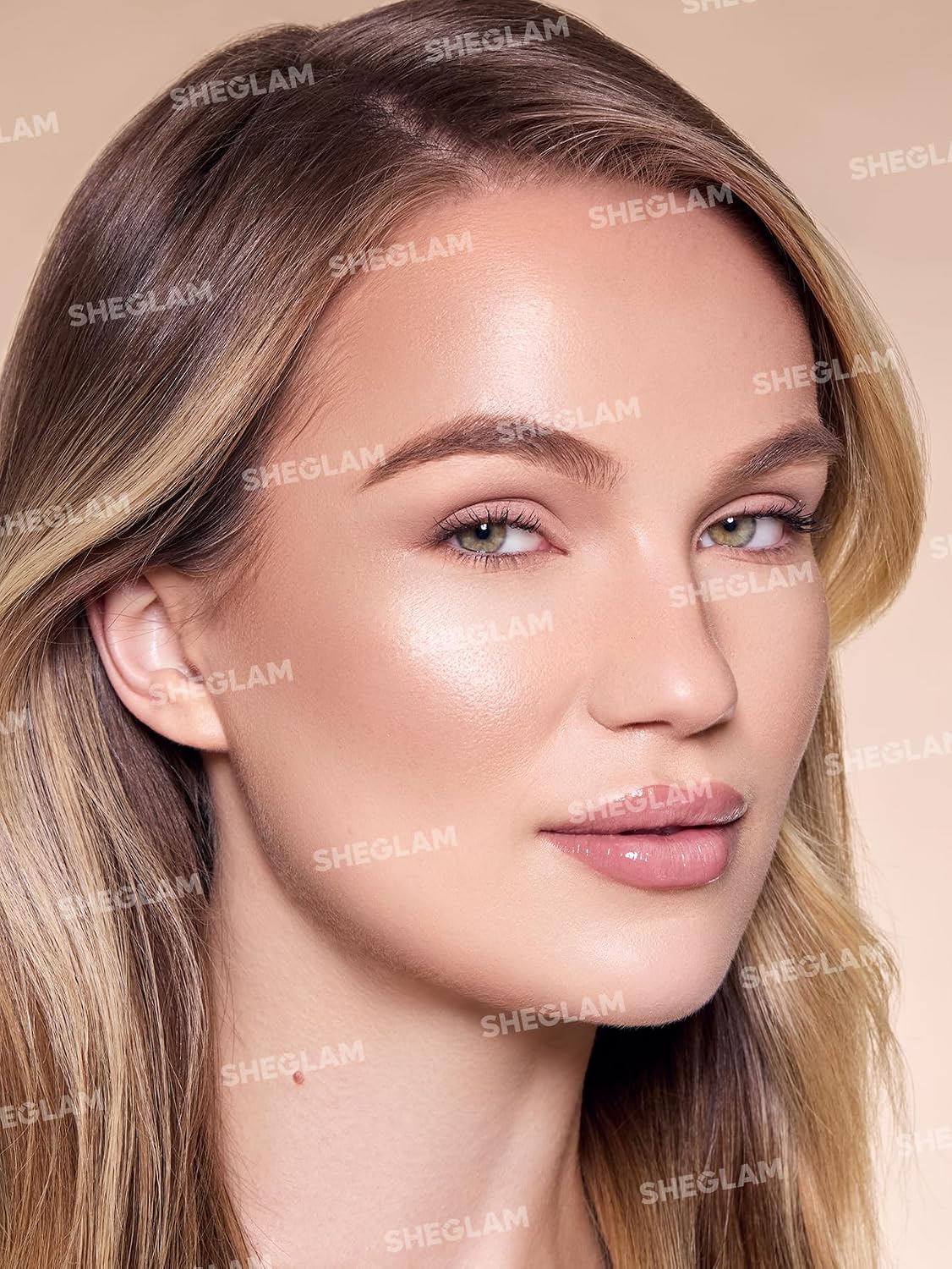 Model applying Sheglam liquid bronzer to cheekbones for sun-kissed look