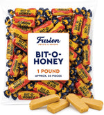Chewy honey taffy candy piece unwrapped showing almond bits