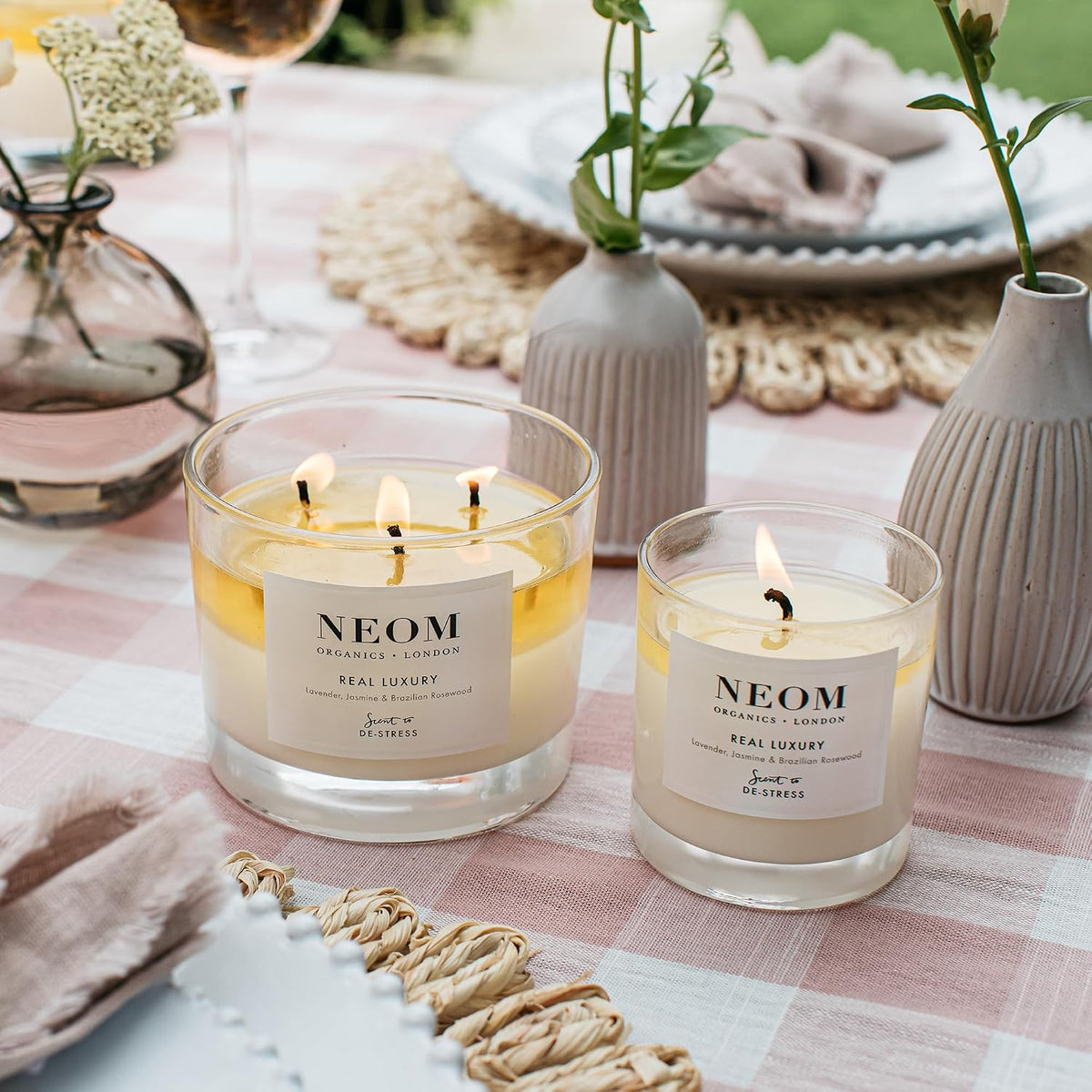 Neom natural wax candle lit in a calm living room setting