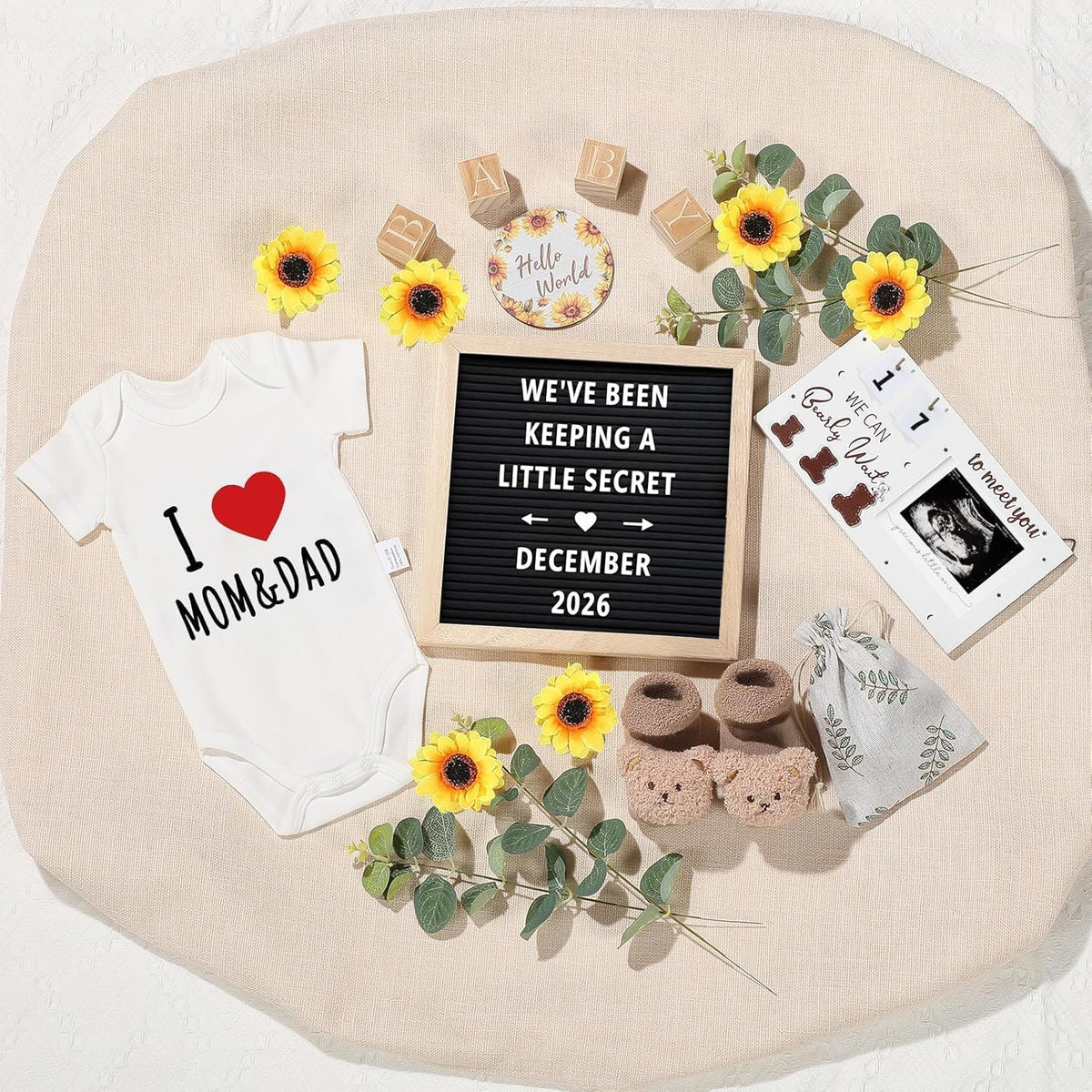 Free-Space pregnancy announcement set front view featuring white felt letter board and baby bodysuit flat lay