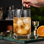Viski crystal cocktail mixing glass filled with ice and a bar spoon.