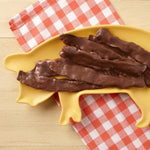 Close up of gourmet Muddy Pigs chocolate bacon with dark chocolate drizzle
