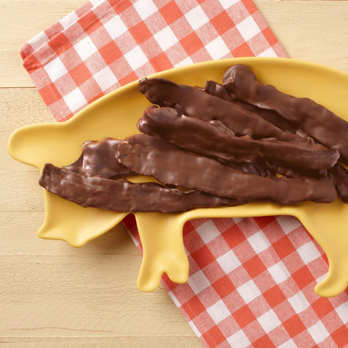 Close up of gourmet Muddy Pigs chocolate bacon with dark chocolate drizzle