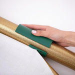Little ELF gift wrap cutter sliding over wrapping paper roll on desk