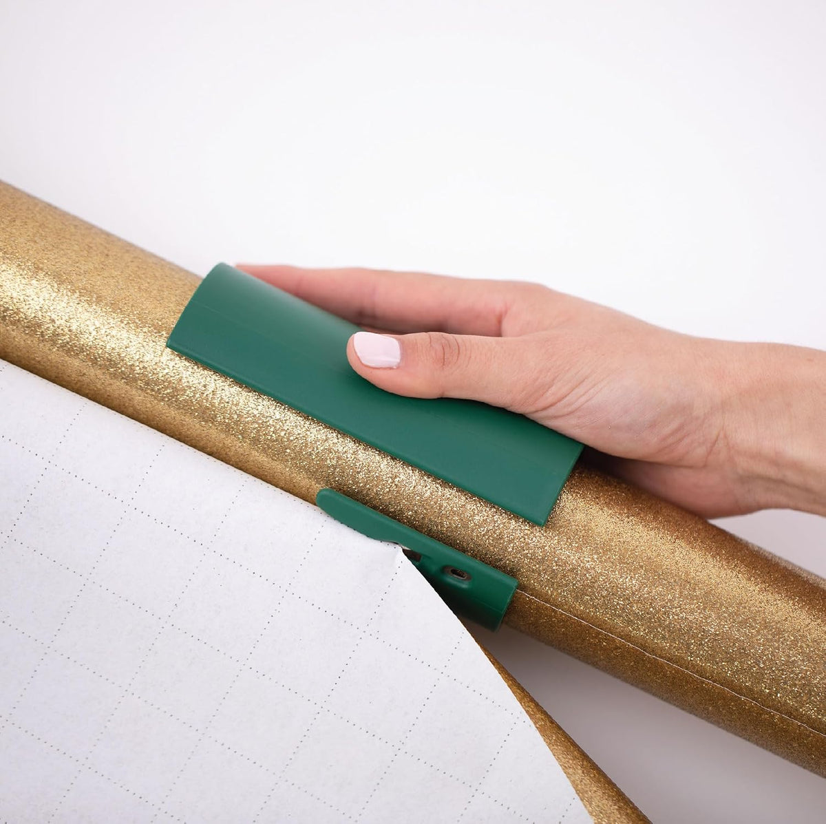Little ELF gift wrap cutter sliding over wrapping paper roll on desk