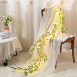 Suncalla lighted olive garland front view draped elegantly across a living room fireplace mantel piece during festive celebrations.
