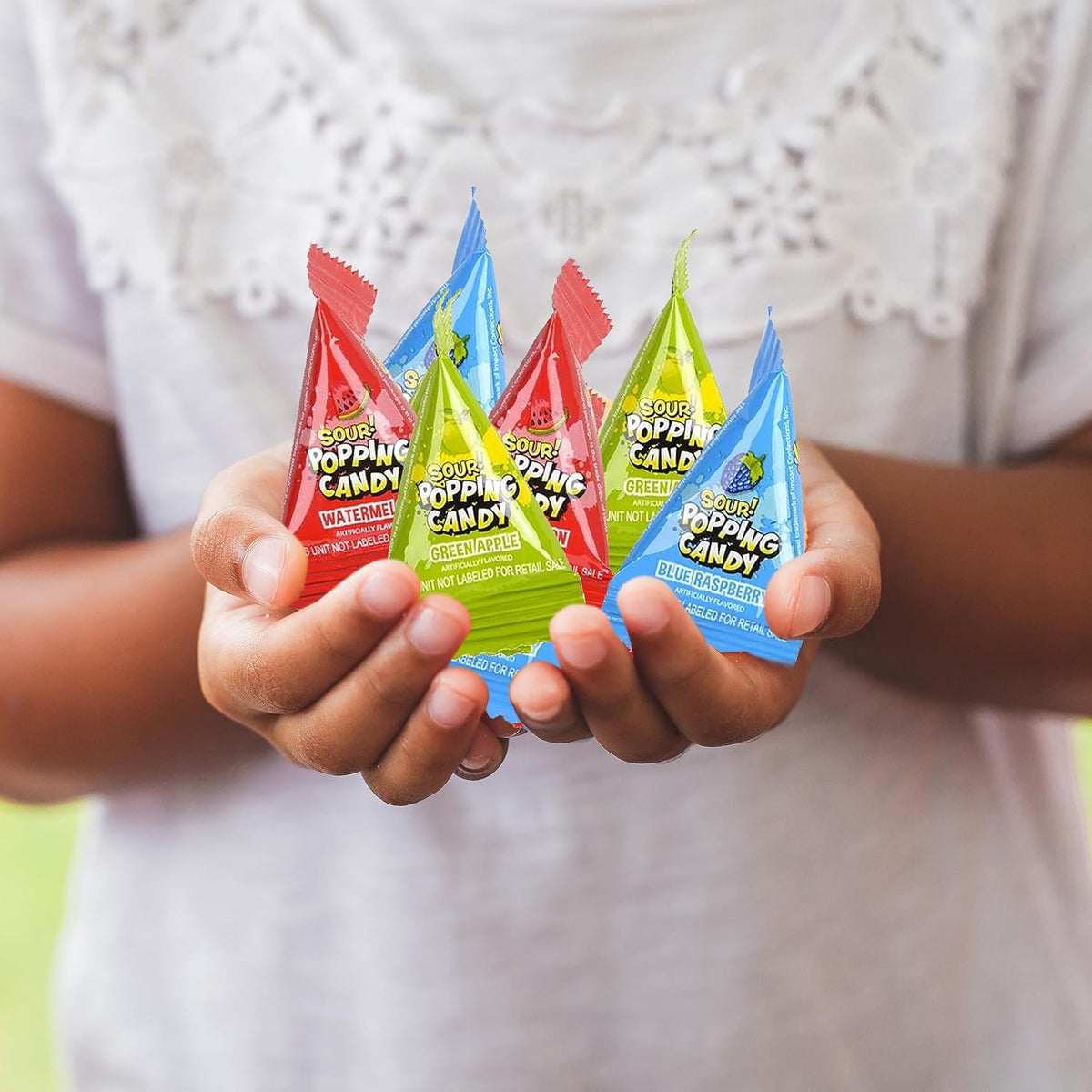 Display of forty mini packs of imported USA sour popping candy ideal for Indian birthday party favors and celebratory treats.