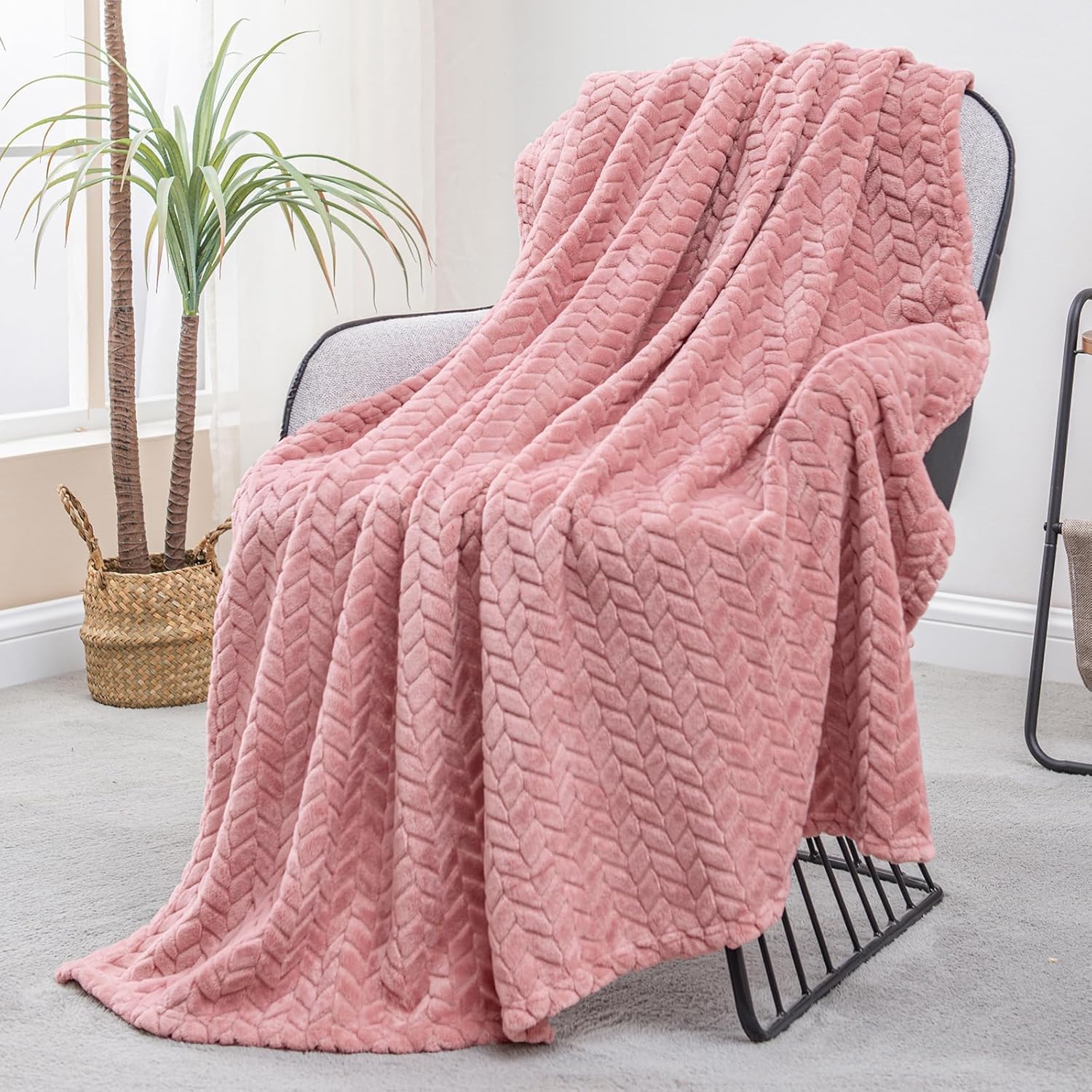 Exclusivo Mezcla dusty pink flannel fleece throw blanket draped on a modern sofa