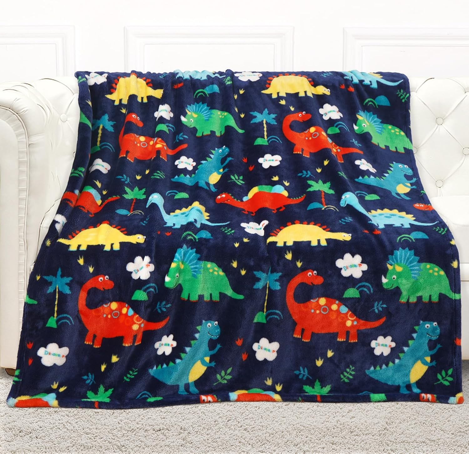 Mermaker toddler dinosaur blanket front view showing deep blue flannel fabric with colorful cartoon dinosaurs.