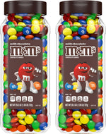 Hand holding a handful of colorful peanut chocolate candies next to the bulk jar