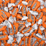 Individually wrapped Tootsie Roll Mango Frooties chewy candies scattered