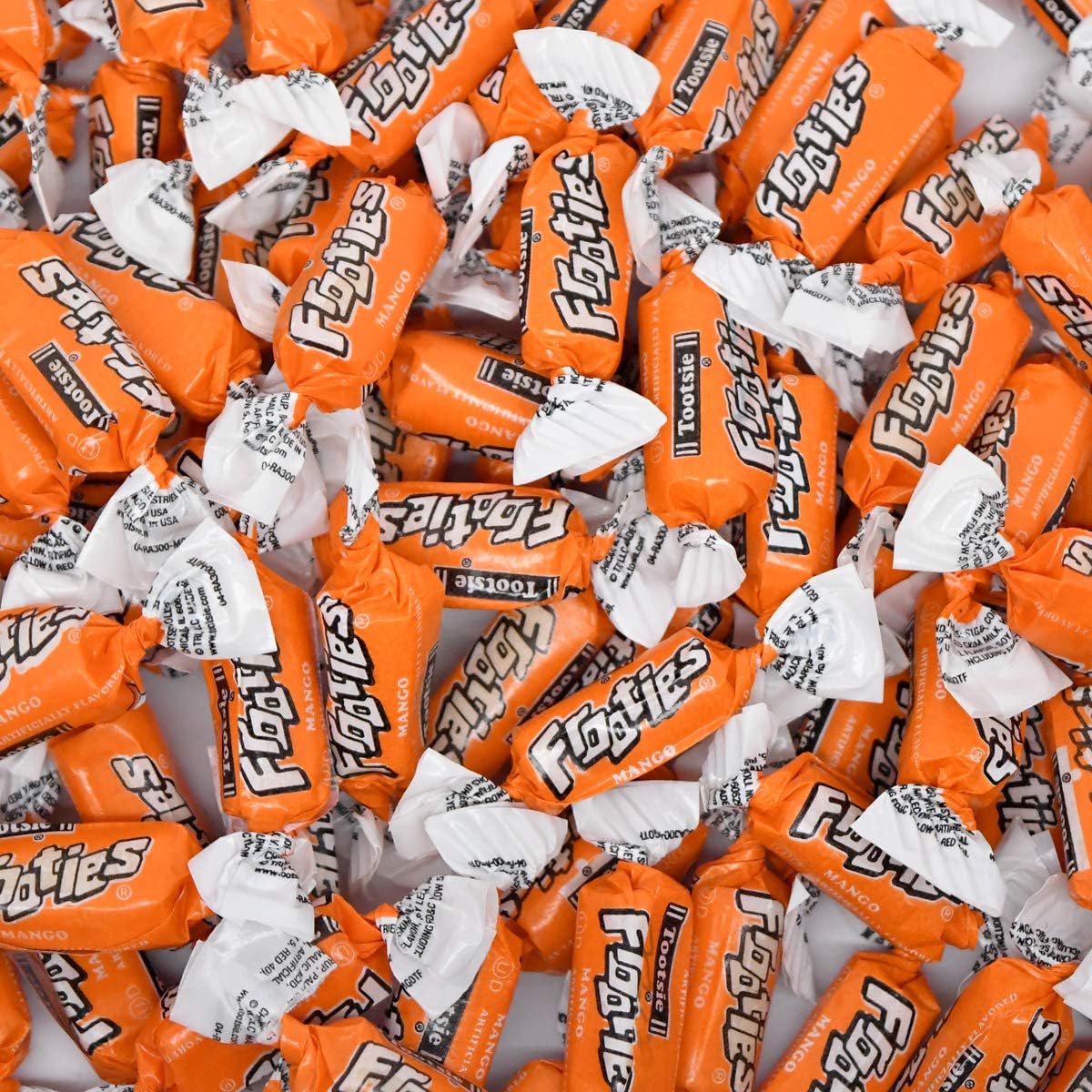 Individually wrapped Tootsie Roll Mango Frooties chewy candies scattered