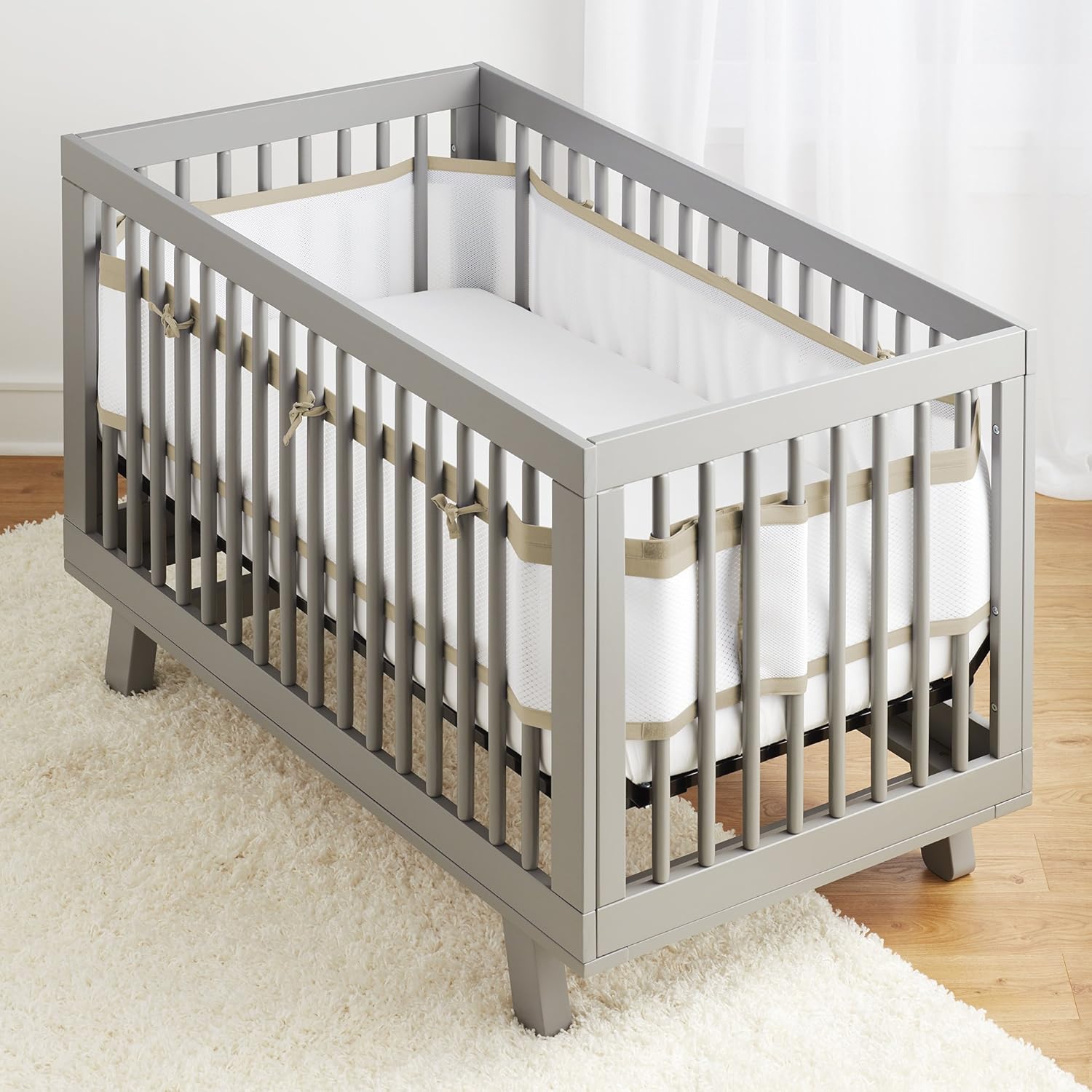 BreathableBaby Deluxe Mesh Crib Liner in natural linen front view installed on a white wooden crib.