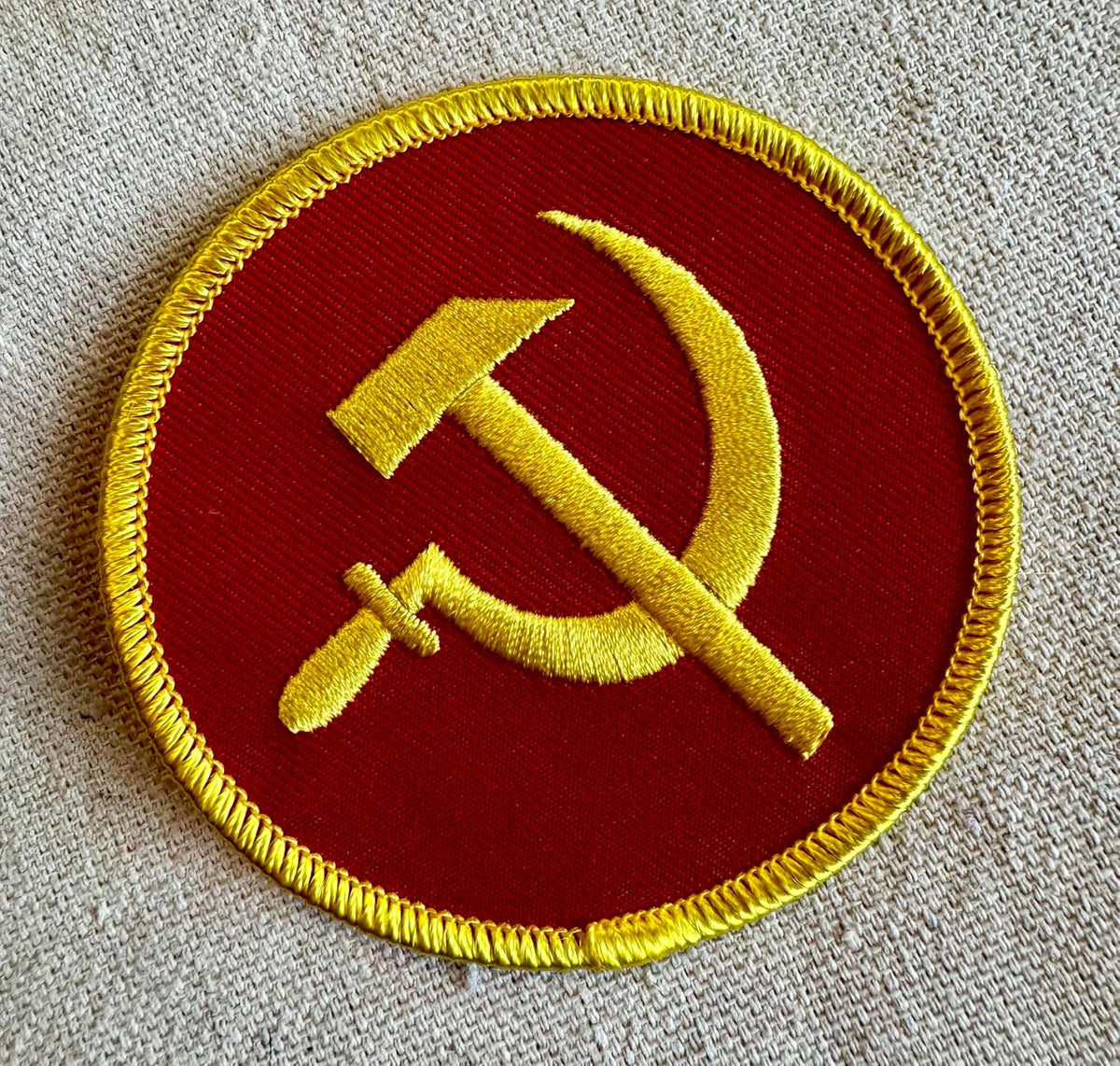 Round red USSR party patch on fabric surface