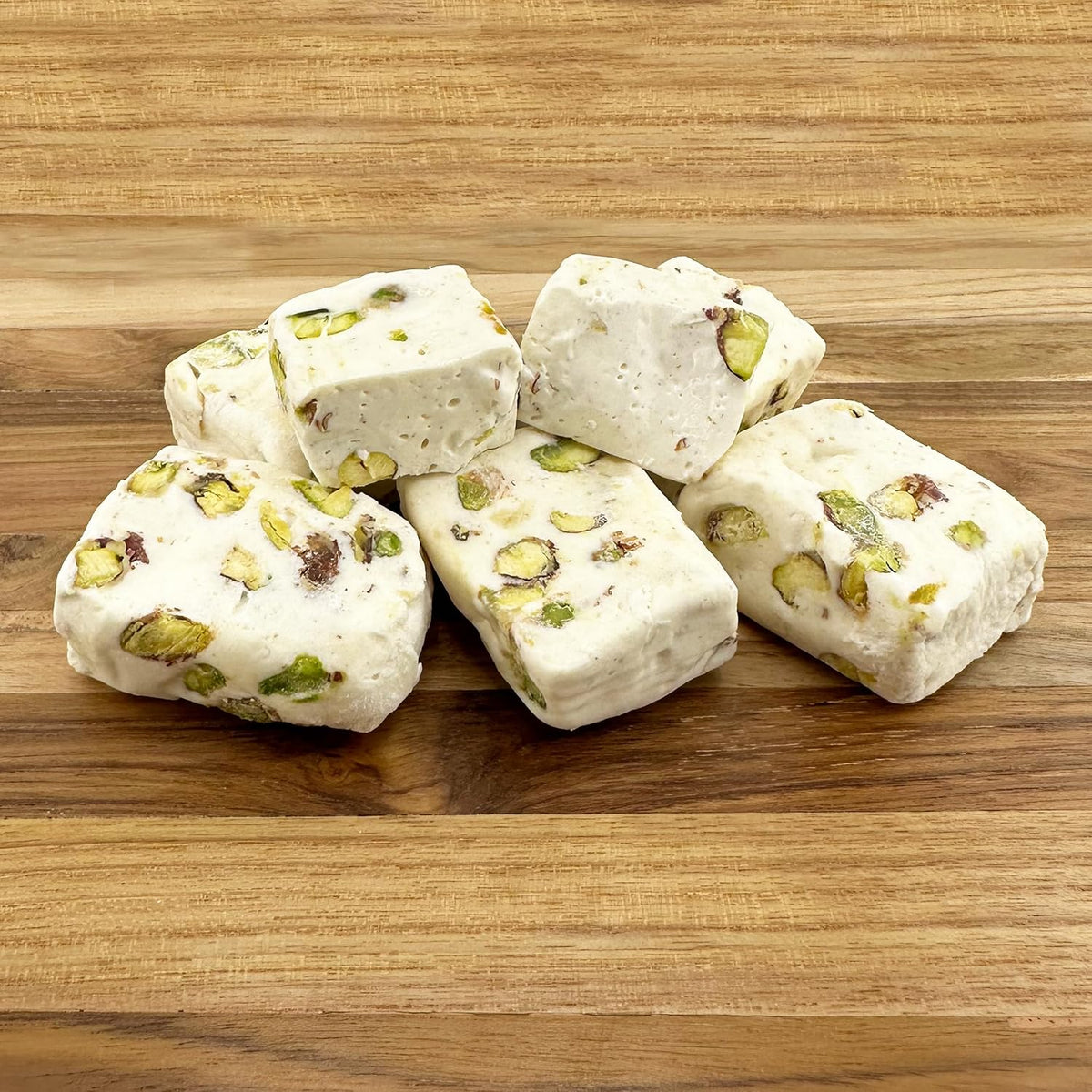 Individually wrapped pieces of pistachio divinity candy spilled from the packaging.