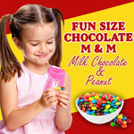 Individually wrapped fun size pouches of chocolate covered peanuts spread out on a table.