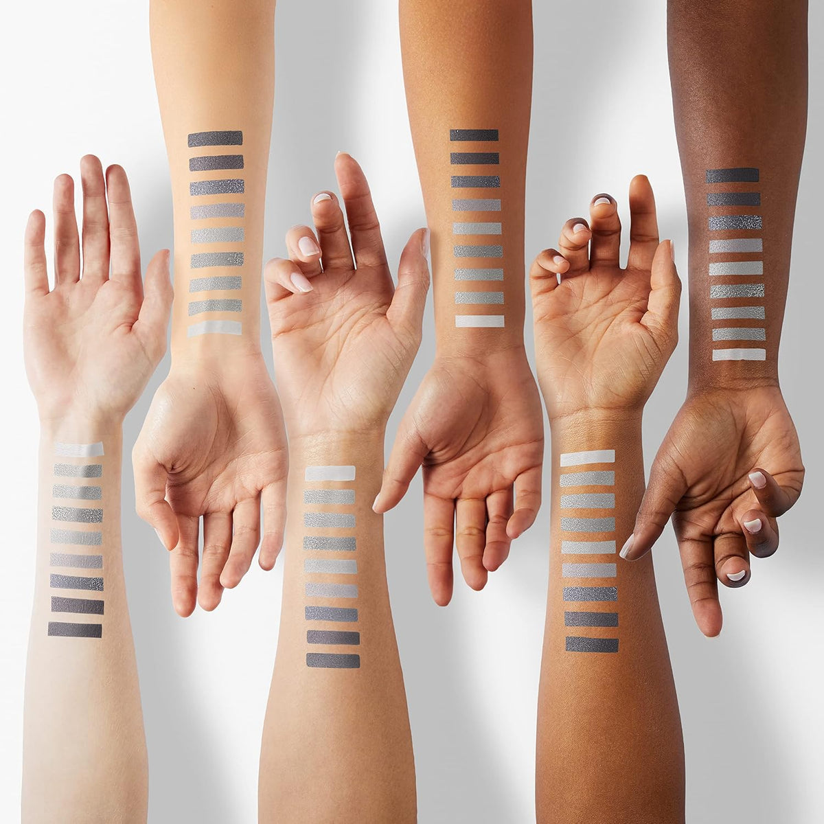 Swatches of silver and black smoky eyeshadow shades on skin