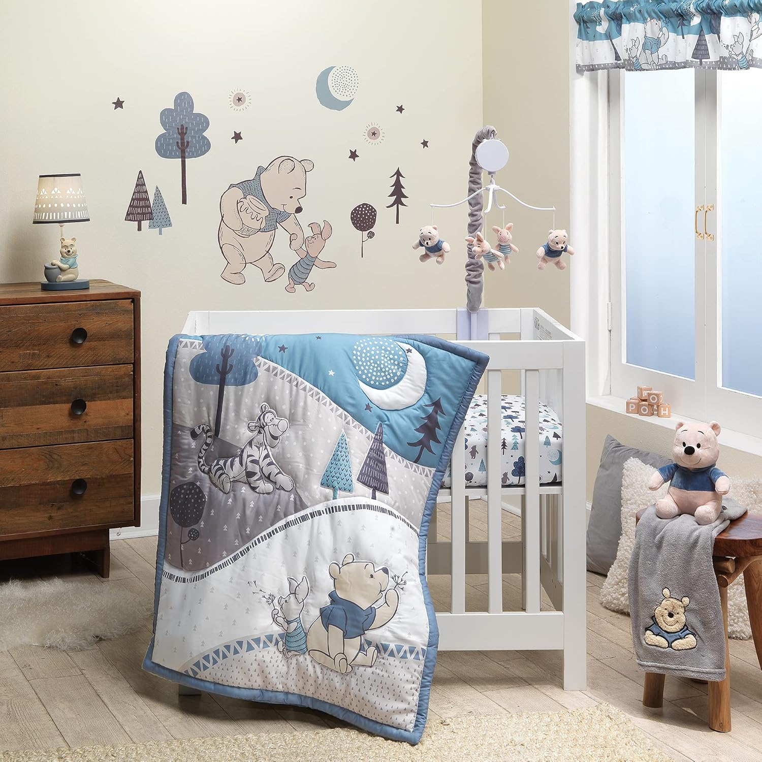 Lambs and Ivy Forever Pooh mini crib bedding set front view showcasing blue quilt with Winnie the Pooh design