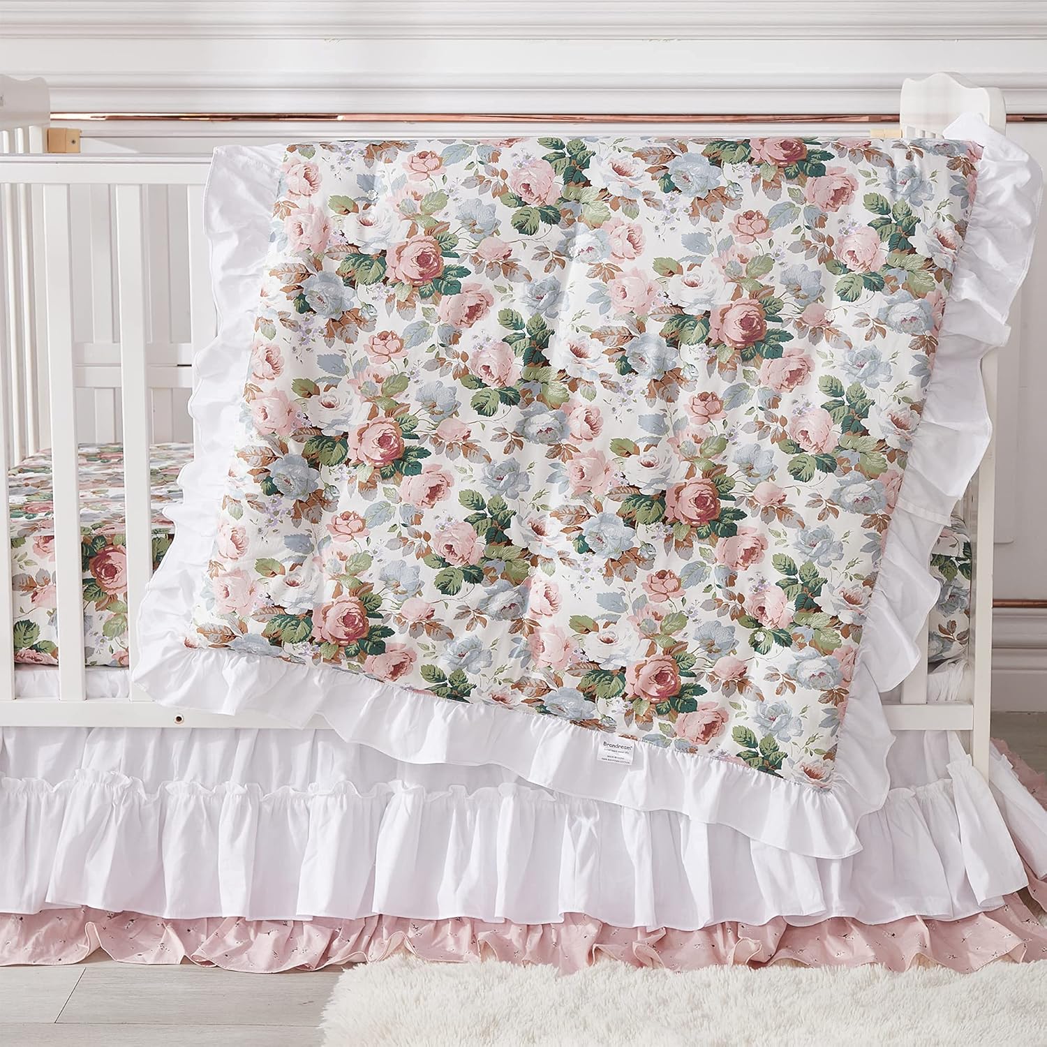 Brandream French Country Garden Floral Crib Bedding Set front view featuring the blush pink ruffled quilt inside a white wooden nursery crib.