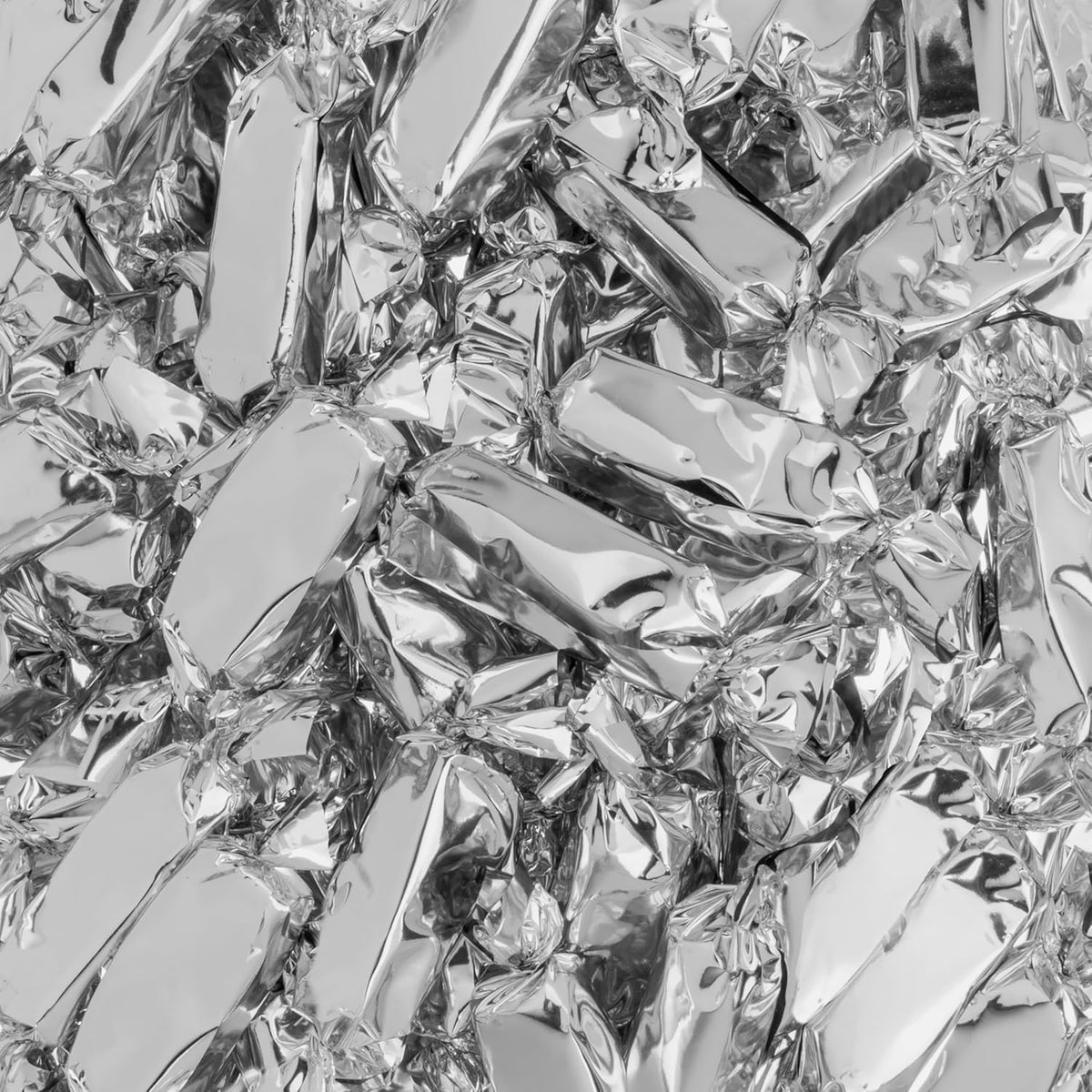 Close up of double wrapped Candy Envy caramel showing clear inner seal and silver outer wrapper.