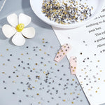 Close up of gold silver and gunmetal metallic nail studs