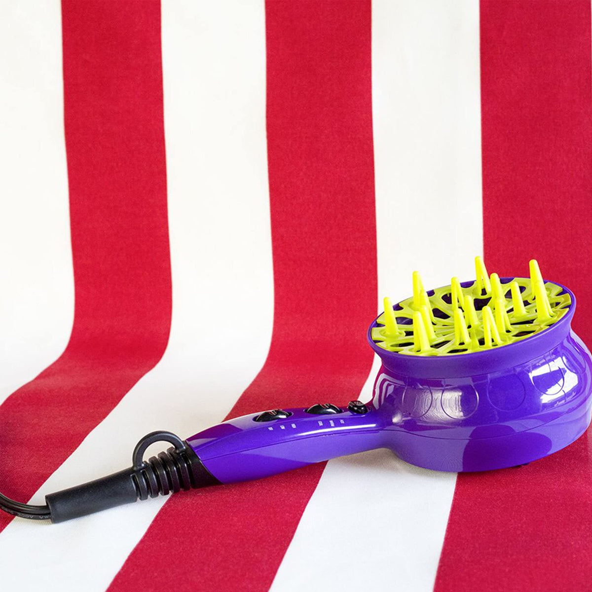 Side profile of the purple Bed Head 1875W hair styling dryer highlighting the heat and speed control switches
