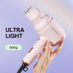 Folded pinky white Wavytalk ionic blow dryer demonstrating its compact travel-friendly design next to its packaging.