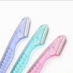 Pink facial hair remover tool with premium stainless steel blade close up