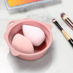 Washing beauty sponge and powder puff inside the pink silicone bowl