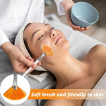 Applying a smooth layer of clay mud mask onto a face using the fan brush.