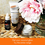 Palmer's exfoliating facial scrub tube with chamomile placed next to natural coconut elements