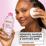Applying Garnier makeup remover using a cotton pad for gentle facial cleansing
