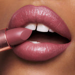 Close up view of the three travel size luxury lipsticks swatched on the back of a hand.