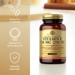 Solgar imported antioxidant vitamin e softgels beside its protective gold cap packaging