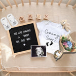 Ultrasound milestone photo frame and wooden blocks included in the pregnancy surprise set.