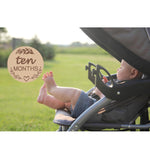 High quality baby monthly milestone discs styled in a nursery flat lay setting