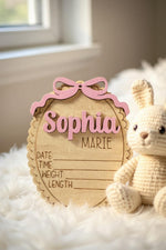 Handmade wooden newborn name plaque with engraved lines for date time weight and length statistics.