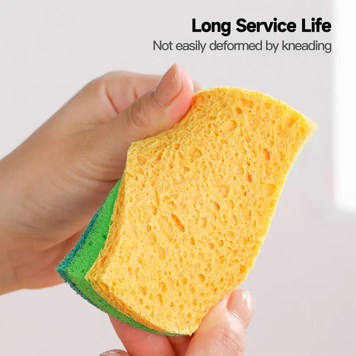 Absorbent wood pulp cotton kitchen sponge wiping a countertop