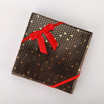 Elasticated packaging loops holding a small jewelry gift box securely closed