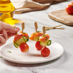Top down perspective of authentic food grade bamboo toothpicks spread across a catering display tray