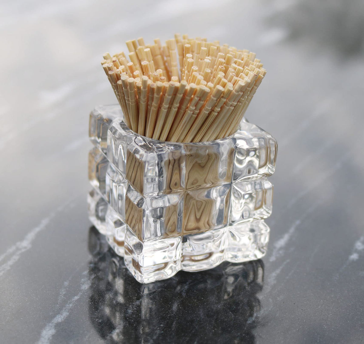 Compact HillSpring glass toothpick container placed elegantly next to a gourmet charcuterie board arrangement.