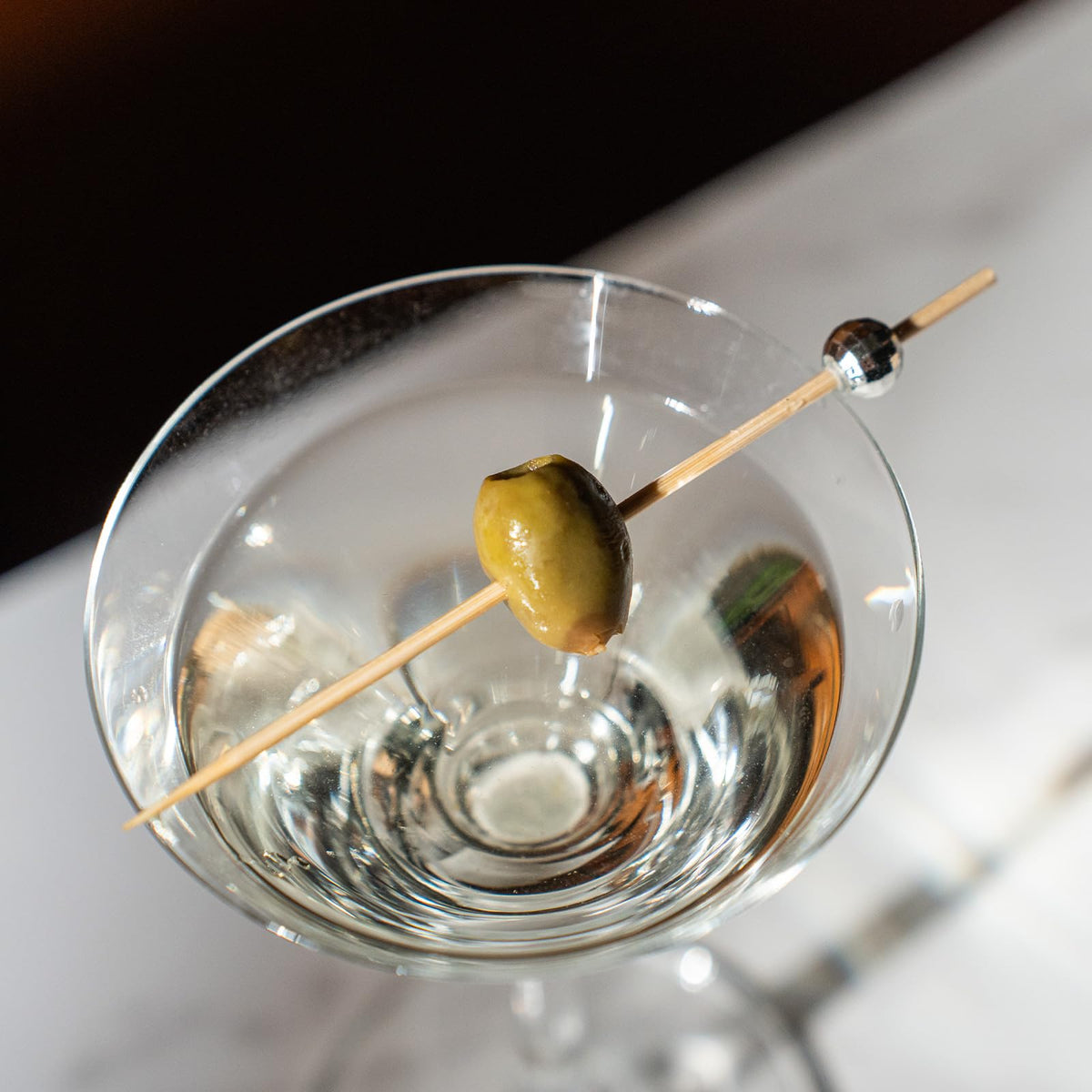 Eco friendly bamboo cocktail picks with reflective silver tops spread out cleanly.