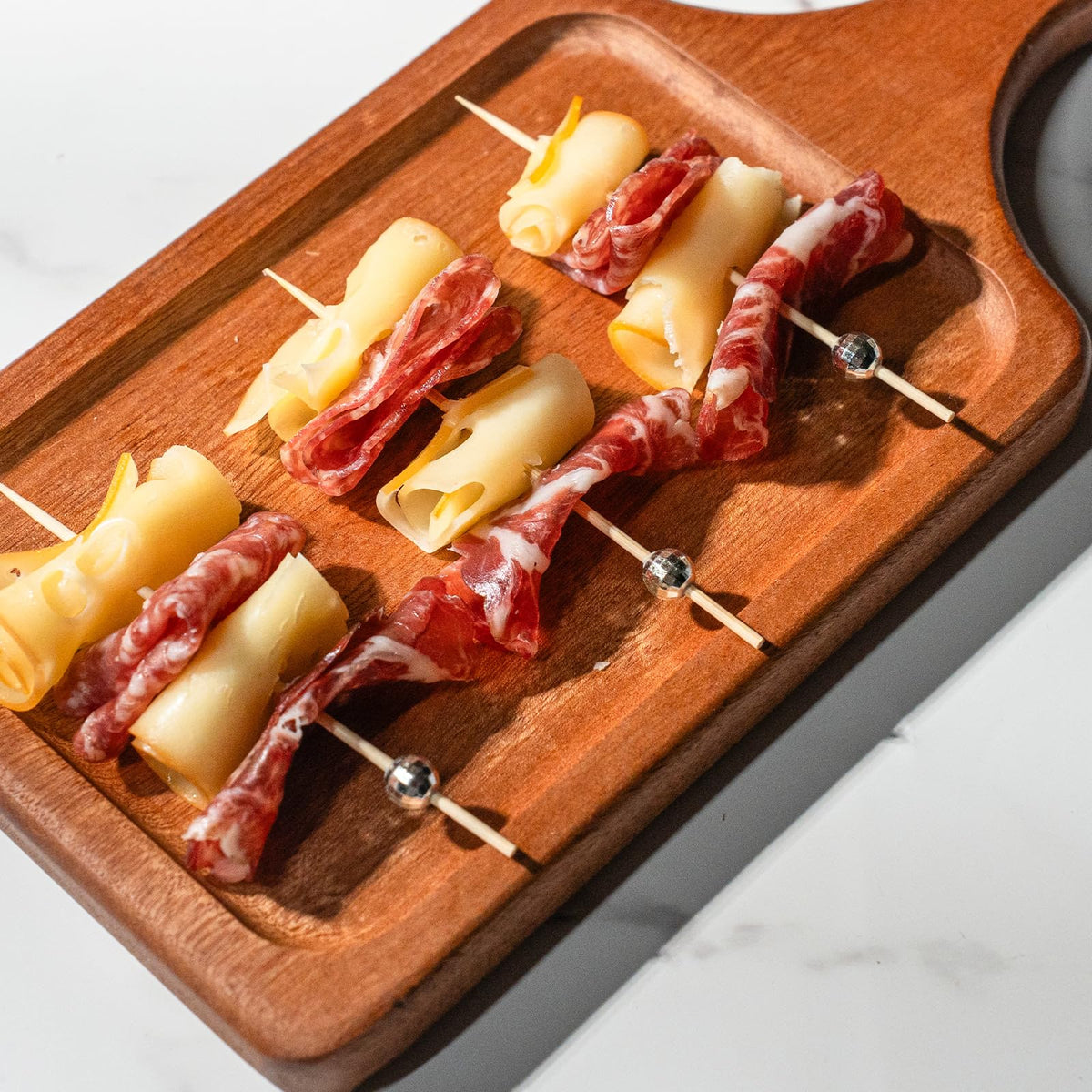 Fancy bamboo skewers by PuTwo arranged neatly on a party charcuterie board setup.