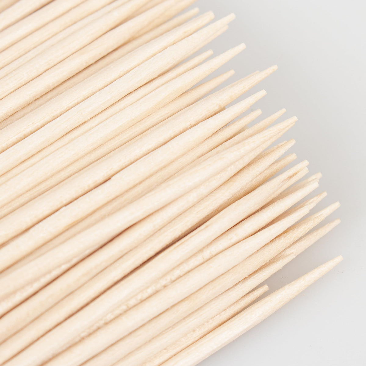 Multifunctional wooden skewers being used at a festive dinner table setting for dental care and finger food.