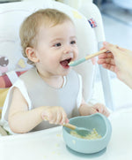 Ginbear adjustable silicone baby bib showing the wide crumb catcher pocket.