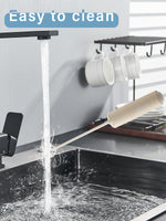 DOOBAANN battery operated small hand blender mixing a smooth latte coffee in a glass cup.