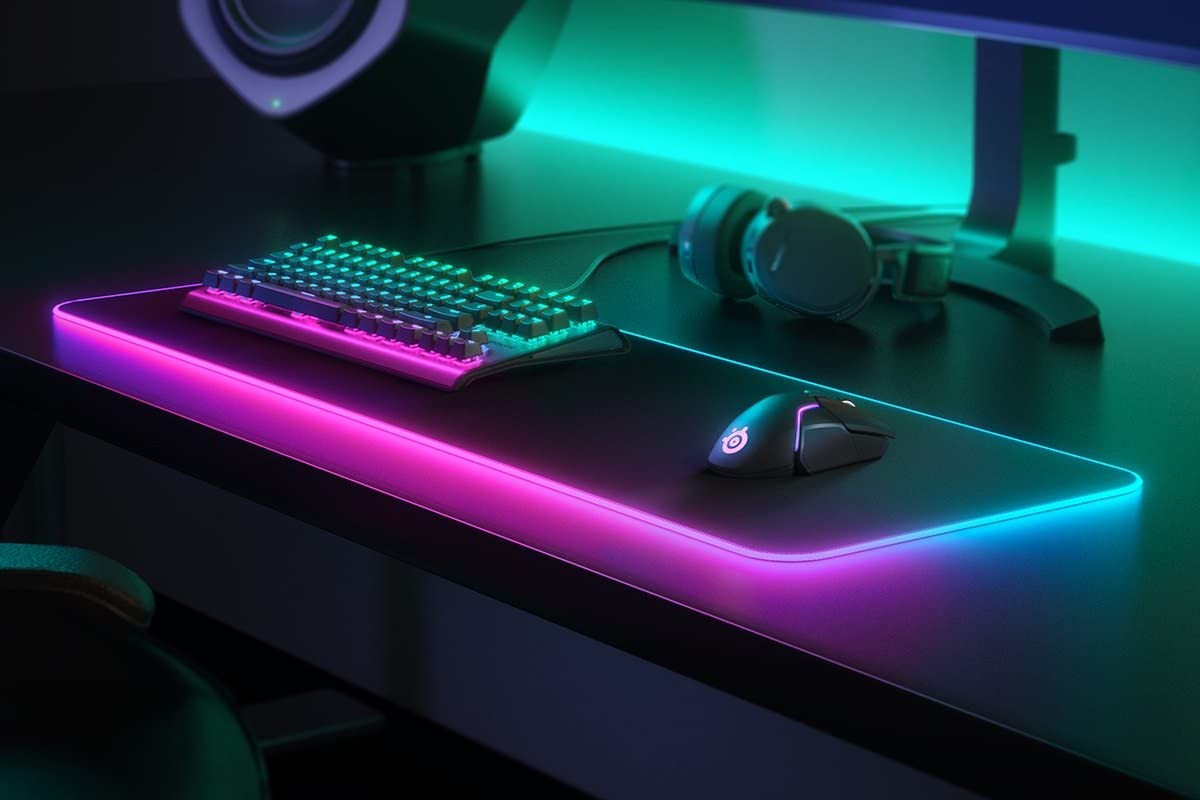 Angled view showcasing the vivid two zone customizable illumination edges of the SteelSeries desktop mouse pad.